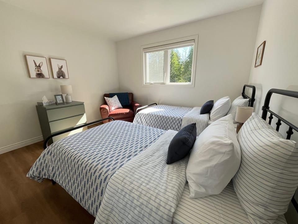 Bedroom 3: The third bedroom offers two twin beds, a comfortable reading chair, and plenty of natural light, making it an ideal retreat for extra guests or younger travelers.