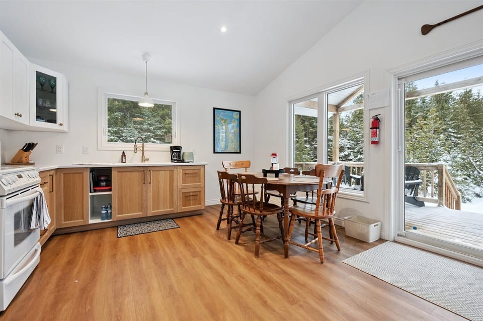 Sun-filled dining area with forest views, perfect for shared meals, board games, or planning your next Bruce Peninsula adventure.