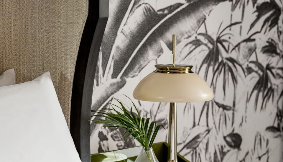 Drift off beneath a statement headboard with soft bedside glow.