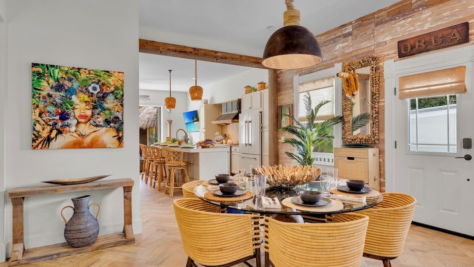 Your stylish dining space flows seamlessly into the fully-equipped kitchen, where exposed beams and vibrant artwork create a warm, inviting atmosphere for memorable meals.