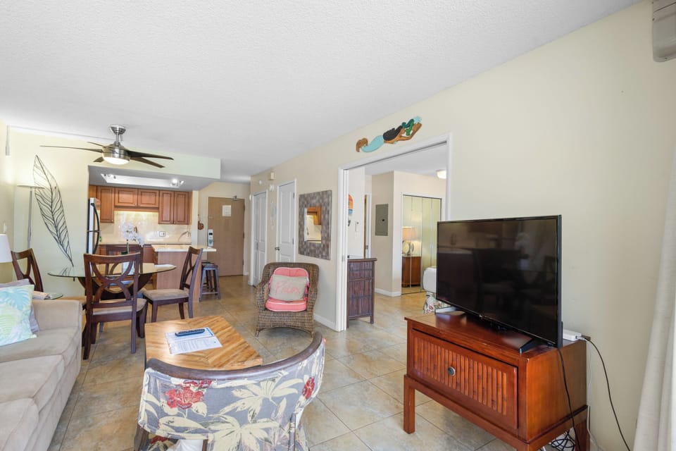 Relax in your spacious open-plan living area with comfortable seating, modern TV, and tropical touches that create the perfect beach getaway atmosphere.