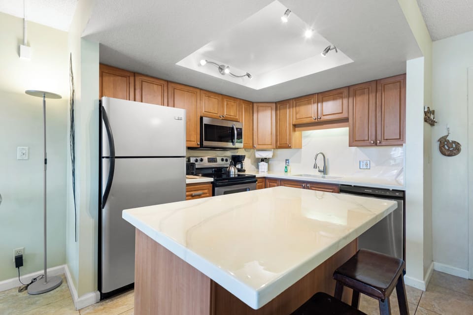 Your fully equipped kitchen features granite counters, stainless appliances, and a breakfast bar perfect for morning coffee.