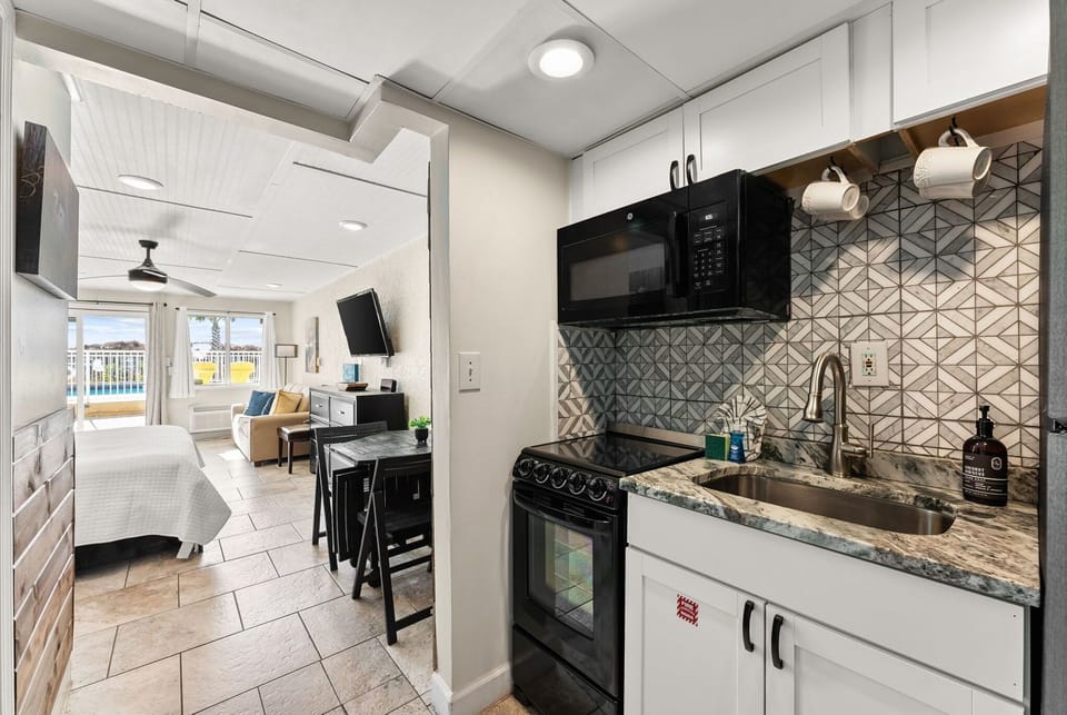 Your modern kitchenette features sleek granite counters and stylish tile backsplash, perfect for preparing meals while staying connected to the bright living space.