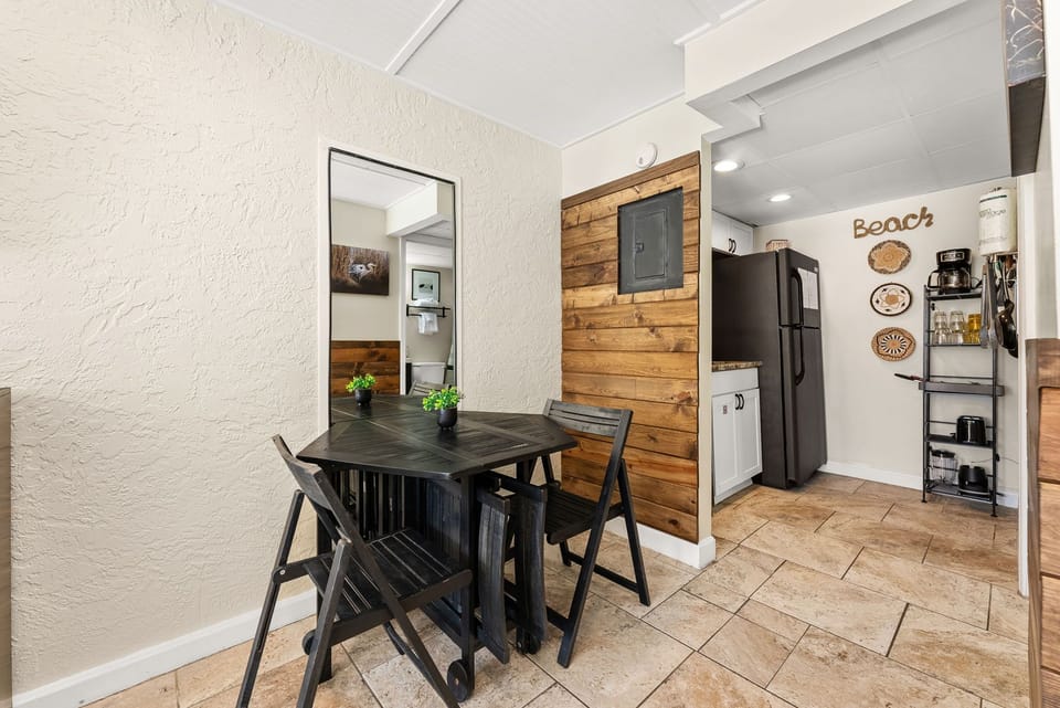 Your beach-themed dining area flows into a fully equipped kitchen with modern appliances and coastal charm.