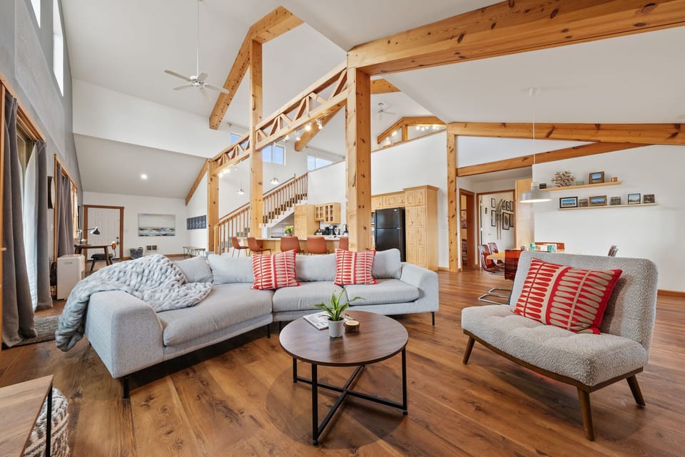 Open living room with vaulted ceilings, exposed beams, and seating area.