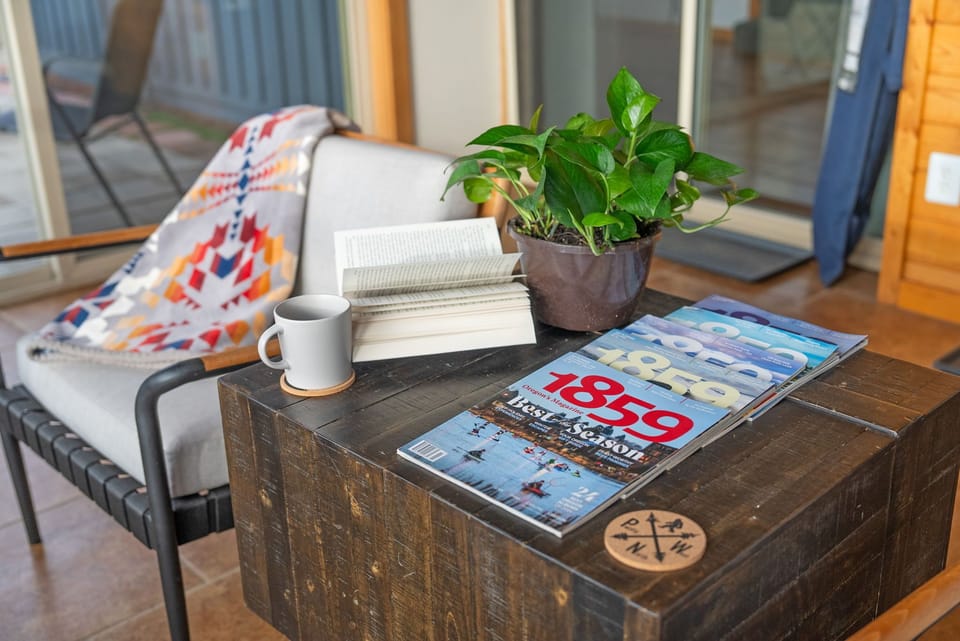 Another angle of living area side table with books, plants, and seating