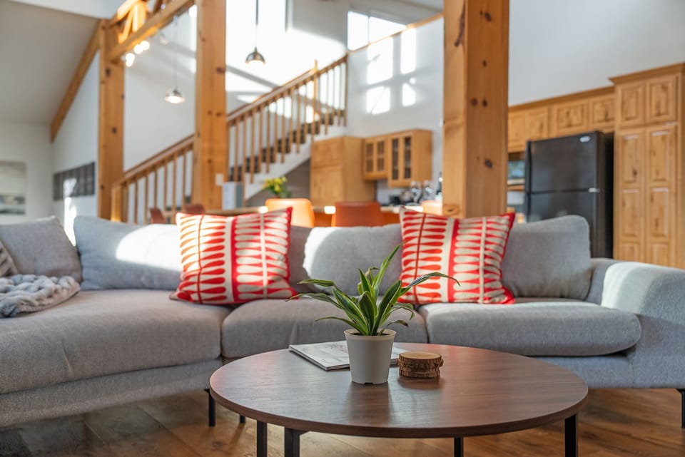 Another photo of the main living room with sofas and open stair views
