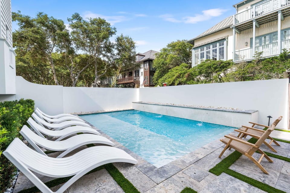 Dive into your private pool oasis, surrounded by sleek loungers and peaceful neighborhood views for ultimate relaxation.