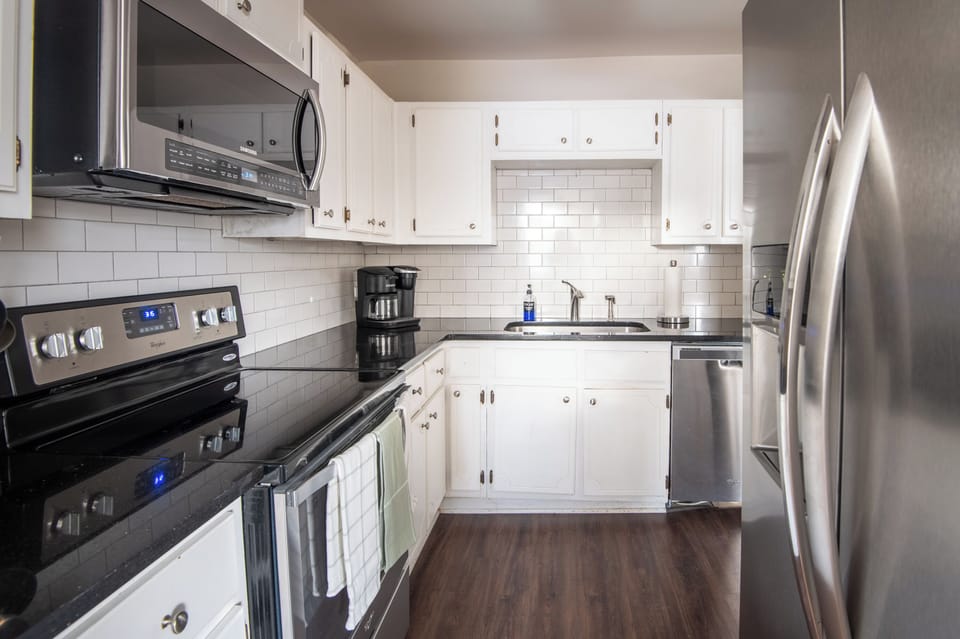 Spacious kitchen layout featuring stainless refrigerator and modern finishes.