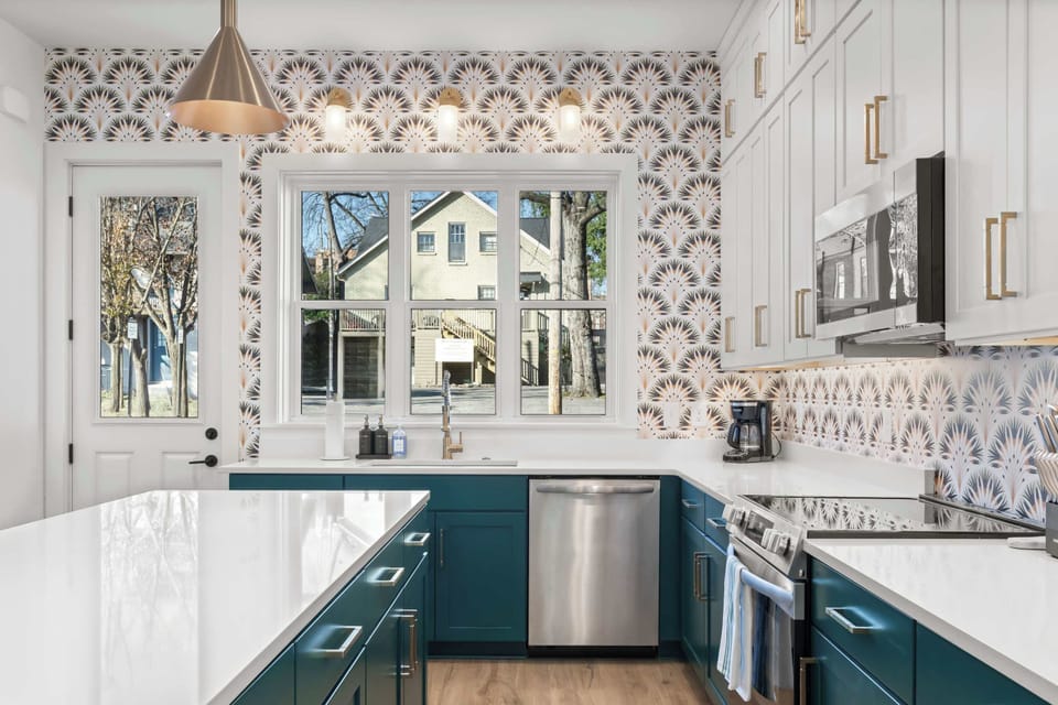 Bright, designer kitchen with a large island, quartz countertops, custom cabinetry, and beautiful natural light from oversized windows.