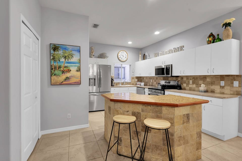 A pair of barstools sit at the eating island that defines the kitchen space.