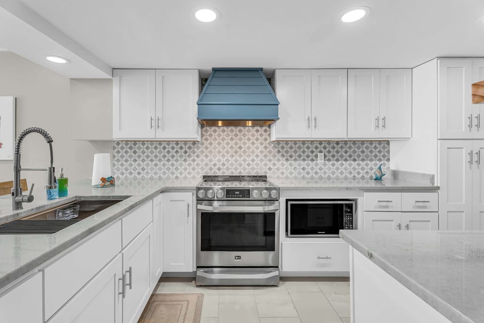 Fully equipped modern kitchen with stainless appliances and ample counter space.