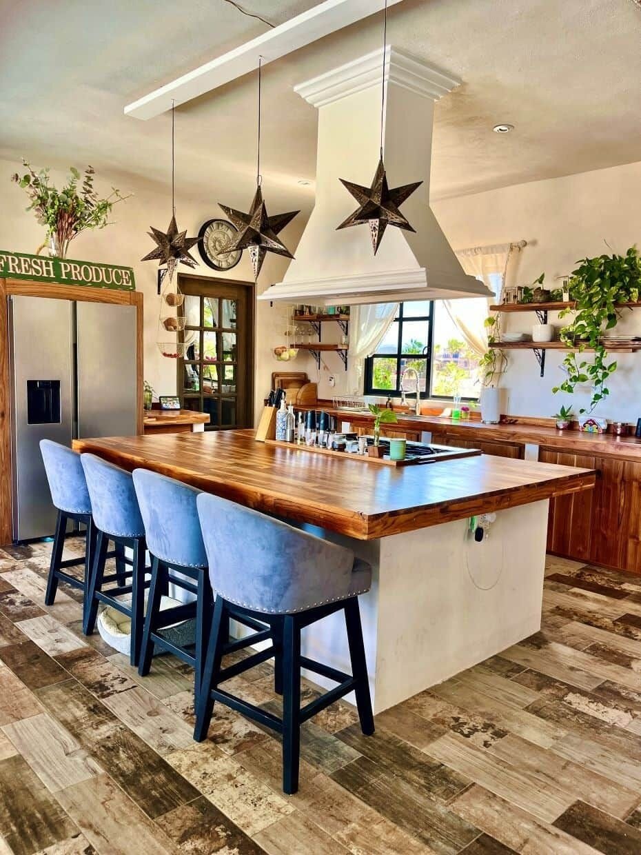 A spacious, ocean-view kitchen with 6-panel foldaway doors that open fully to the patio, creating an easy indoor-outdoor cooking and gathering space. Features a commercial range, dishwasher, filtered water, and anything you may need to cook meals. 