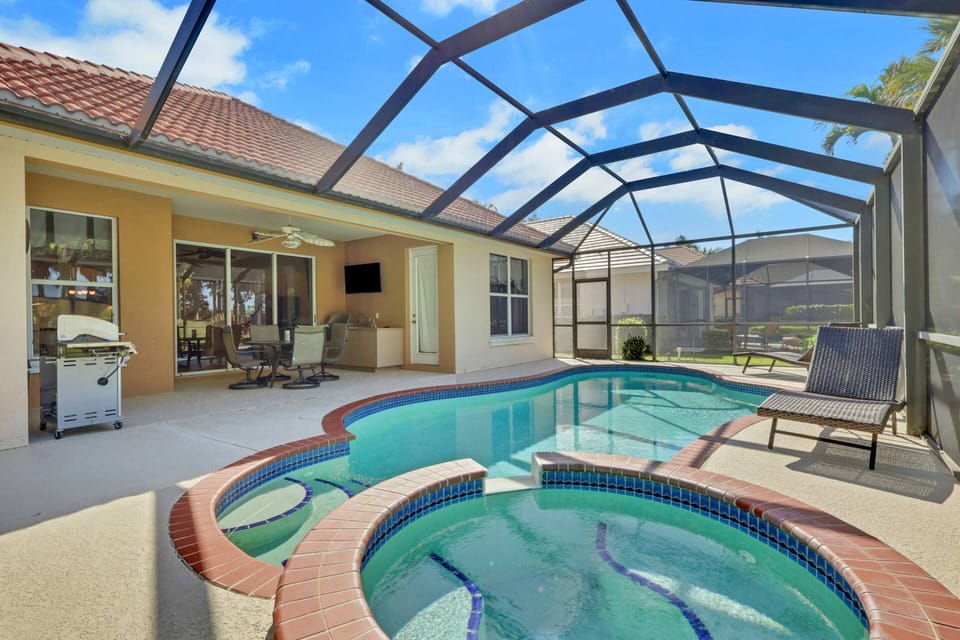 The fully screened lanai boasts a private heated pool, hot tub, BBQ grill, outdoor dining and TV.