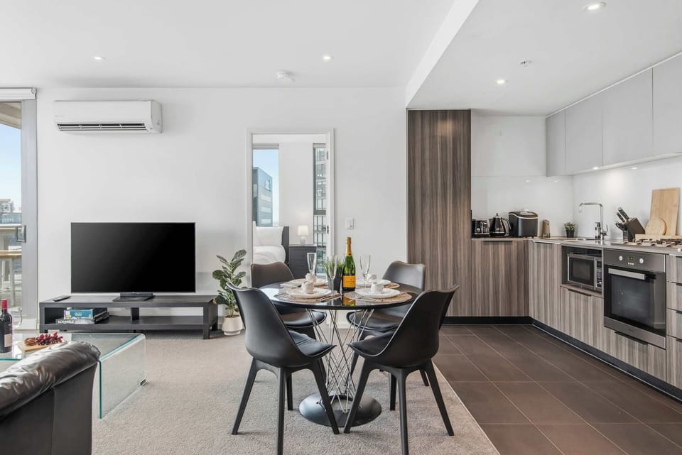 Open‑plan apartment with living area, dining table and modern kitchen creating a contemporary and functional space.