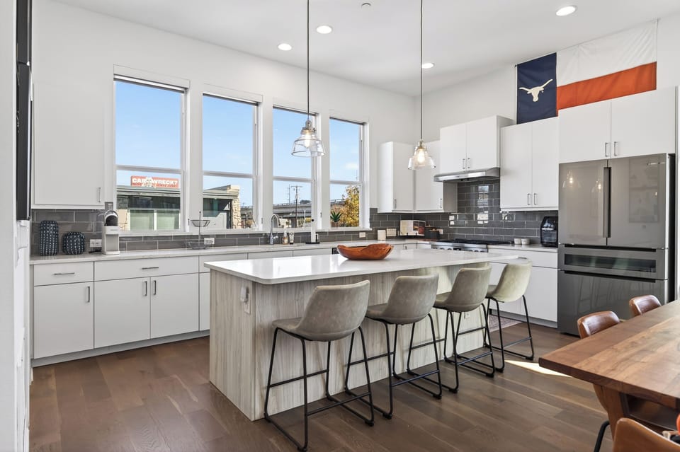 Bright kitchen featuring a large island, sleek cabinetry, and pendant lighting.