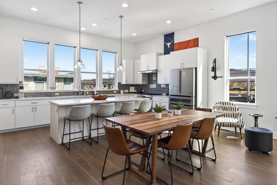 A kitchen and dining area combination featuring a wooden table and a breakfast bar.