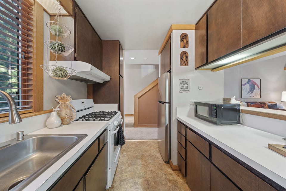 A warm, wood-accented galley kitchen with generous prep space and a charming cabin feel.