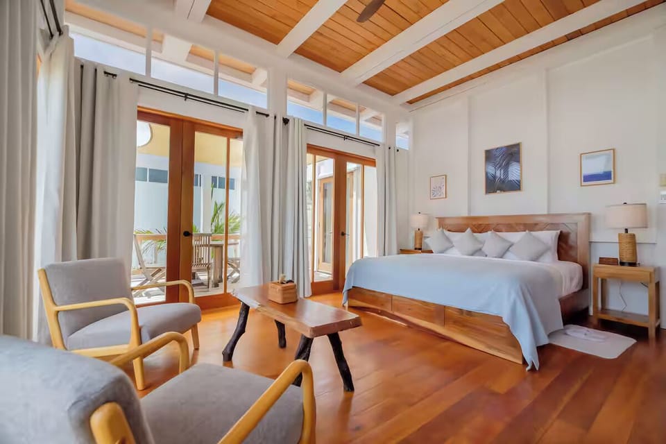 Unwind in a sunlit king bed with airy coastal design.