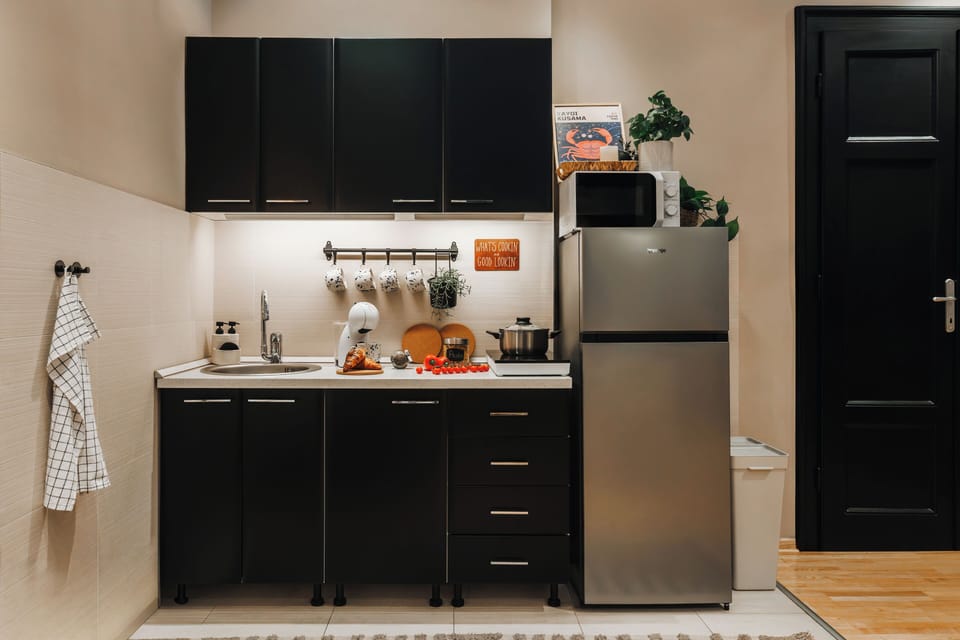 Kitchen with stove, fridge, coffee machine, microwave, cookware