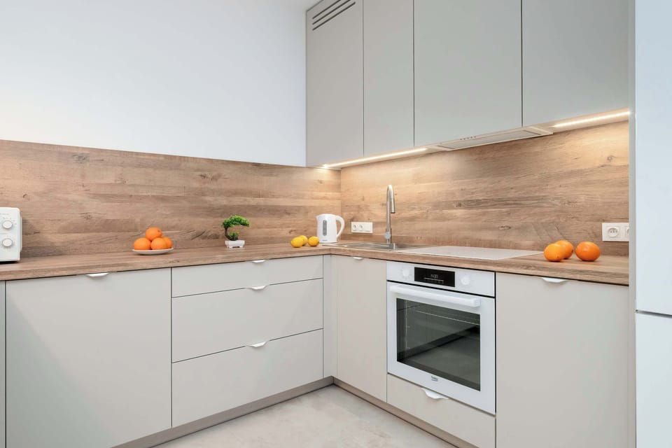 The modern kitchenette with light cabinetry and wooden accents invites you to prepare meals in a stylish and practical setting.