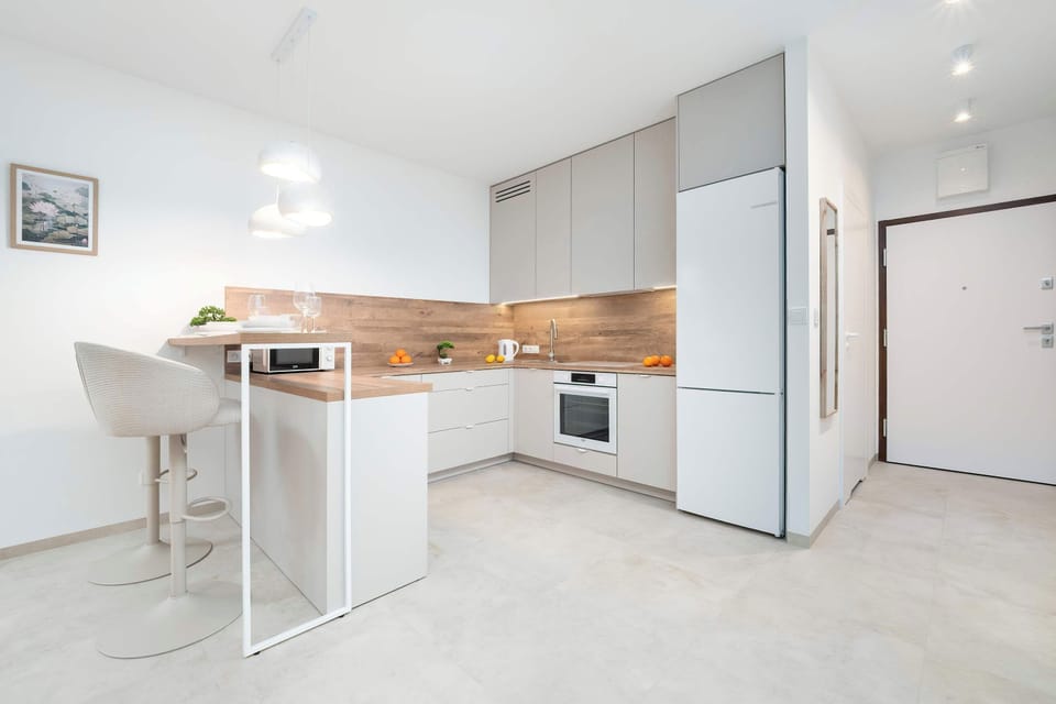 The bright kitchen with an island and bar stools creates a comfortable spot for a quick breakfast or coffee, supporting an easy daily rhythm.