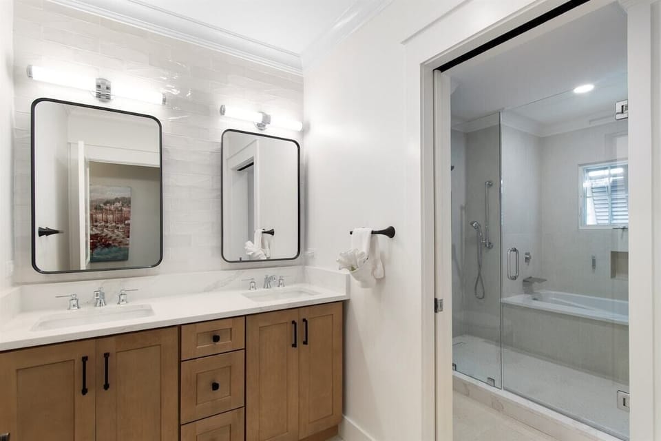 Start the day comfortably at the primary bathroom's double vanity, with the tub and shower in the adjoining bathing area.