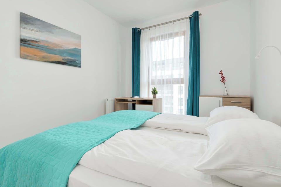 Serene bedroom with white walls, soft bedding, and natural daylight.