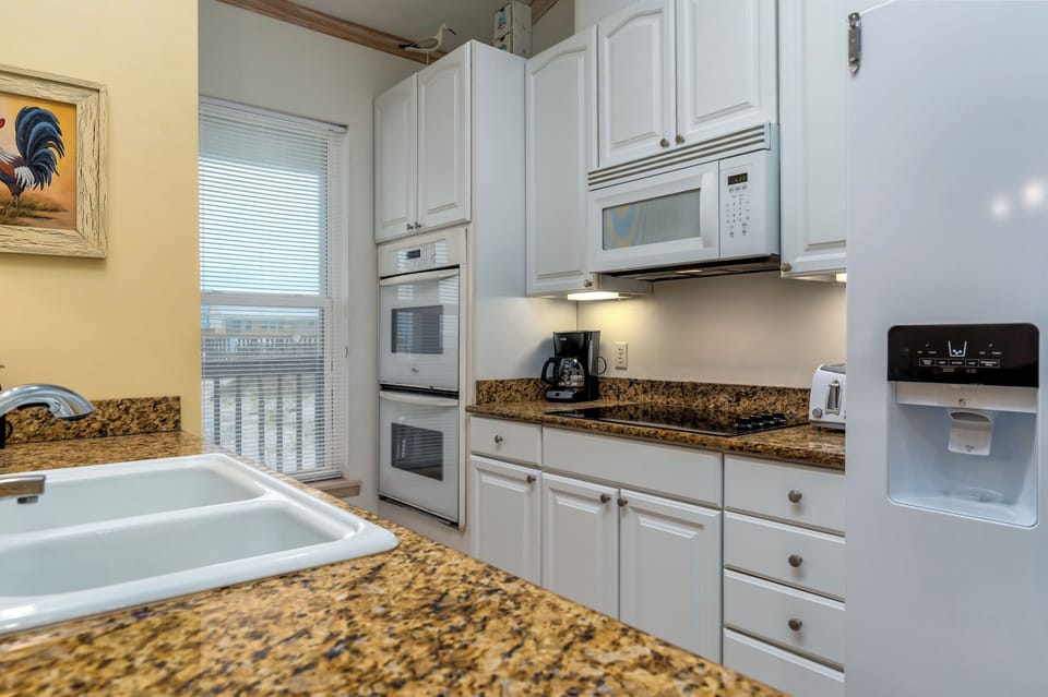 Your fully equipped kitchen features granite counters, white appliances, and everything needed for memorable meals together.