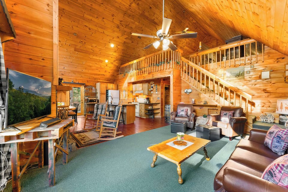 Open-concept living with a cozy stone fireplace, soaring ceilings, and mountain charm.