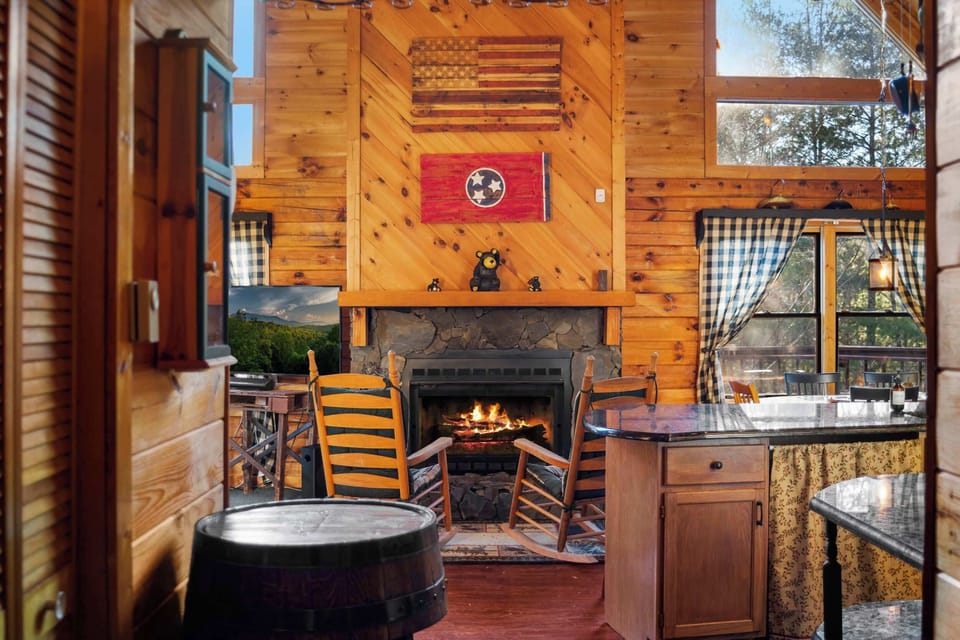 Cozy up by the stone fireplace in our inviting, light-filled open-concept living area.
