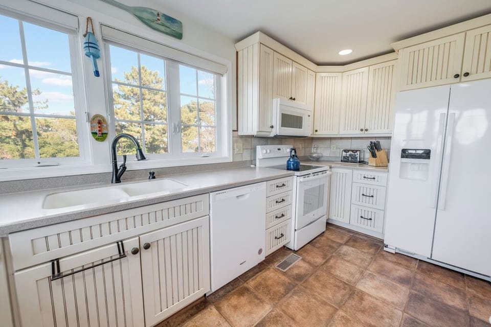 The Chef in your family will adore the well-stocked Kitchen with white beadboard cabinets, granite counters, and windows overlooking peaceful trees—perfect for morning coffee prep.
