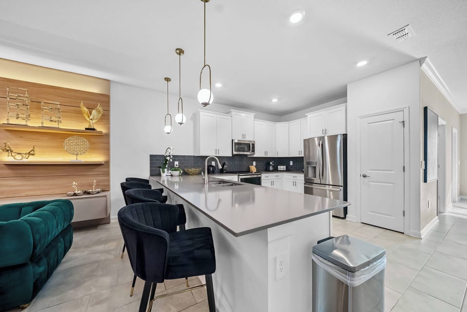 Experience a stylish kitchen with stainless steel appliances and a spacious island topped with polished countertops, complemented by warm wood accents and ambient lighting for a welcoming atmosphere perfect for cooking and.