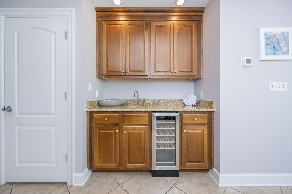 Enjoy refreshing beverages from the sleek wet bar, perfect for socializing during your beachfront getaway