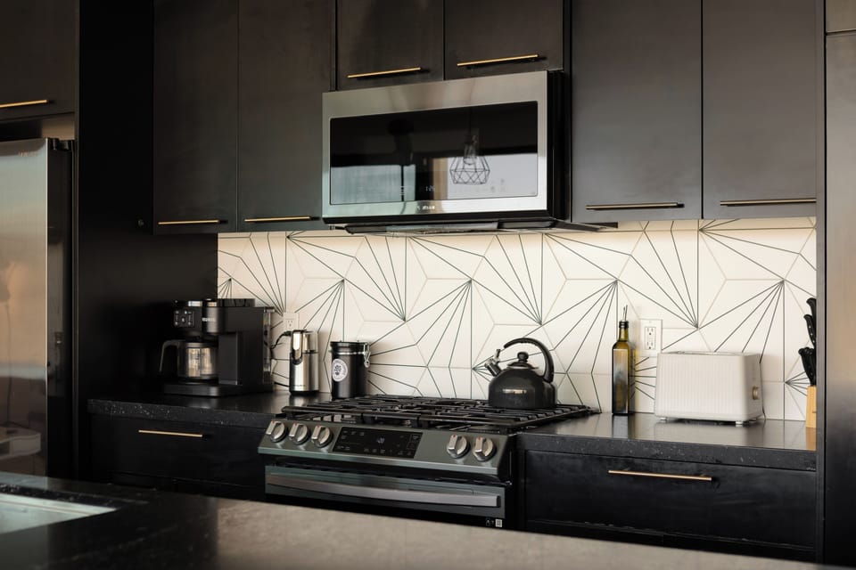Stylish modern kitchen with gas range, coffee station, and bold backsplash