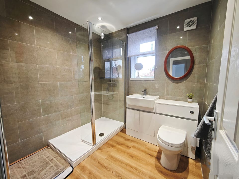 Sparkling clean bathroom with a full shower, towels, and toiletries provided