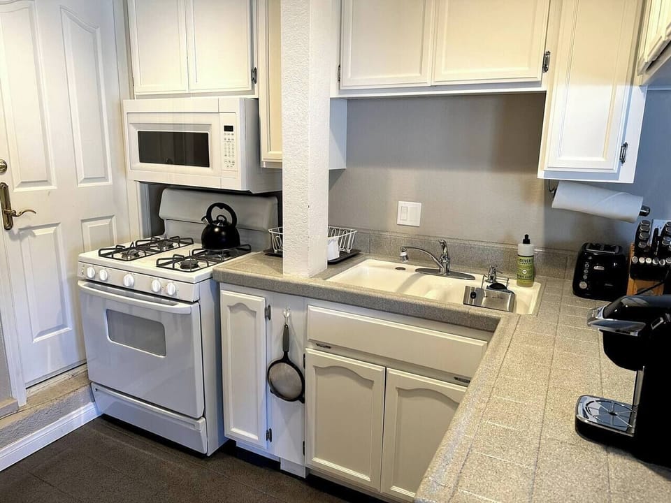 Fully stocked kitchen with all essential supplies and seating for two at the bar.