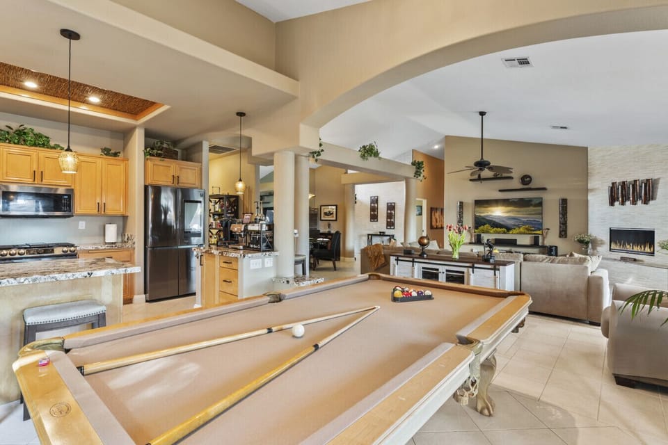 Open kitchen & dining area w/ large island, pool table nearby & seamless entertaining space