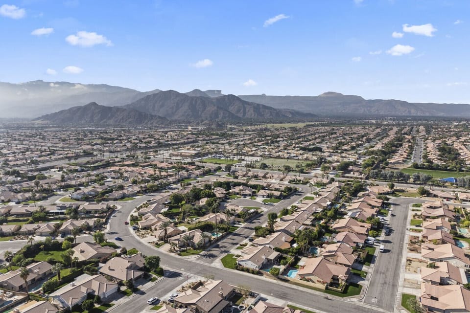 Sweeping aerial views of the surrounding neighborhood set against scenic mountain backdrops