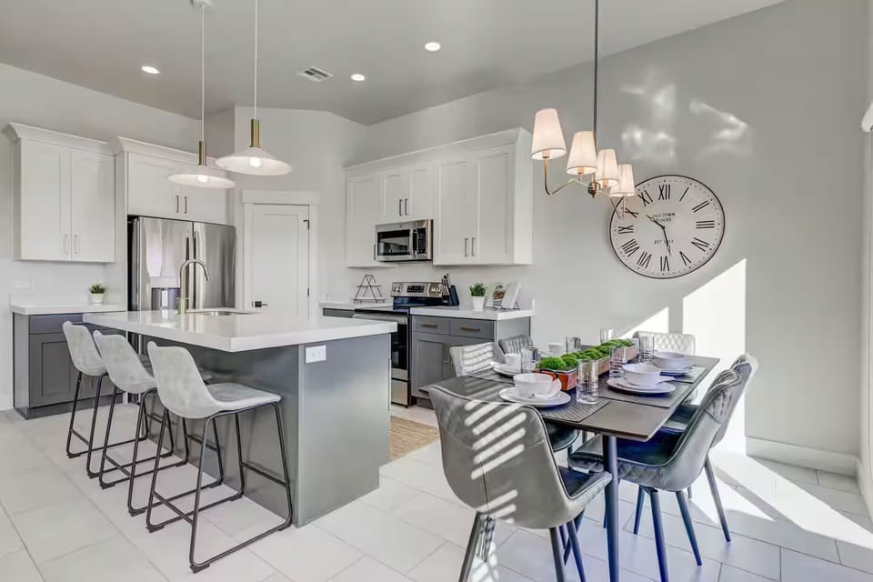 Kitchen featuring place settings for 9 comfortably, with 4 additional seats at outdoor dining table on patio.