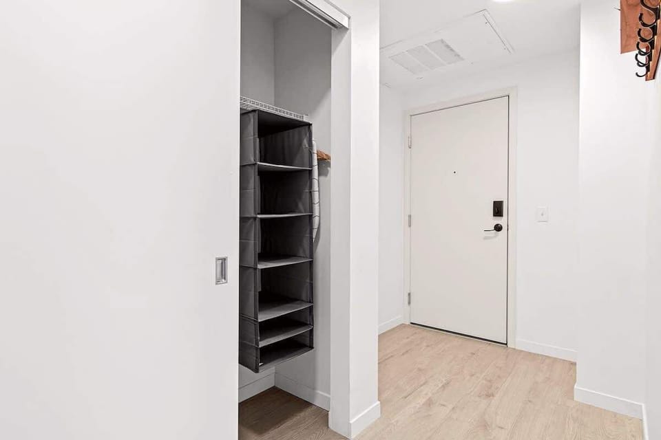 Spacious walk-in closet with organized hanging shelves and storage — perfect for keeping your belongings neat during extended stays.