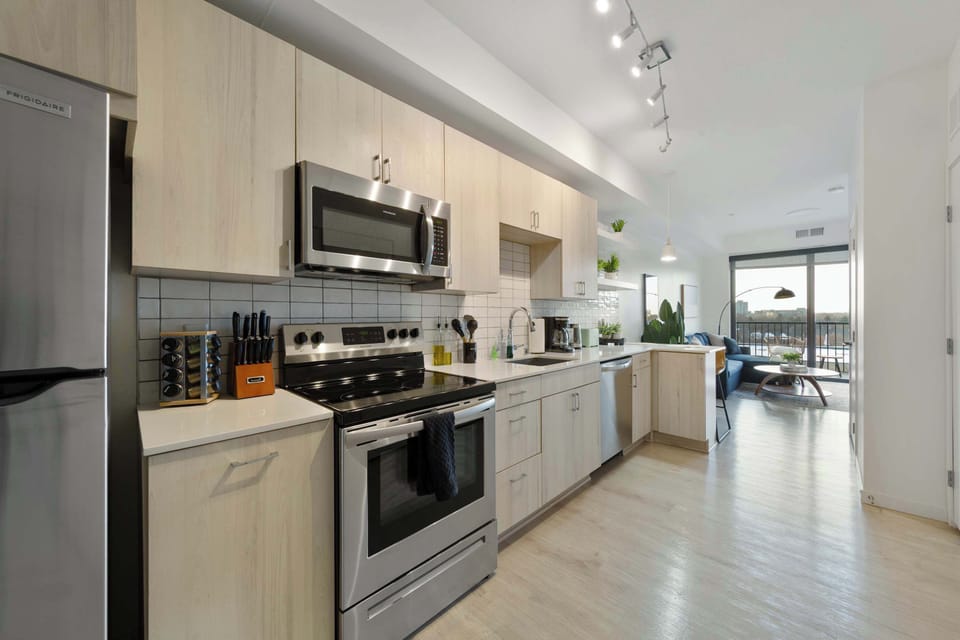 A spacious kitchen with stainless steel appliances and ample counter space for meal prep. The open layout and modern finishes make this kitchen an inviting area to cook, eat, or socialize.