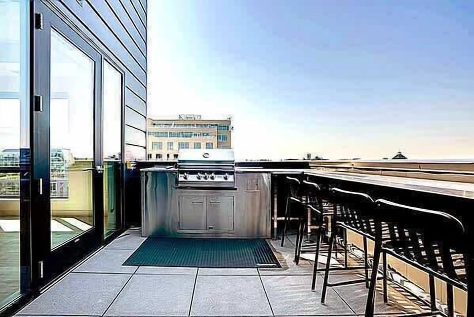 Rooftop lounge area featuring bar seating, grilling space, and expansive city views. Ideal for casual gatherings, sunset moments, or enjoying the skyline from above.