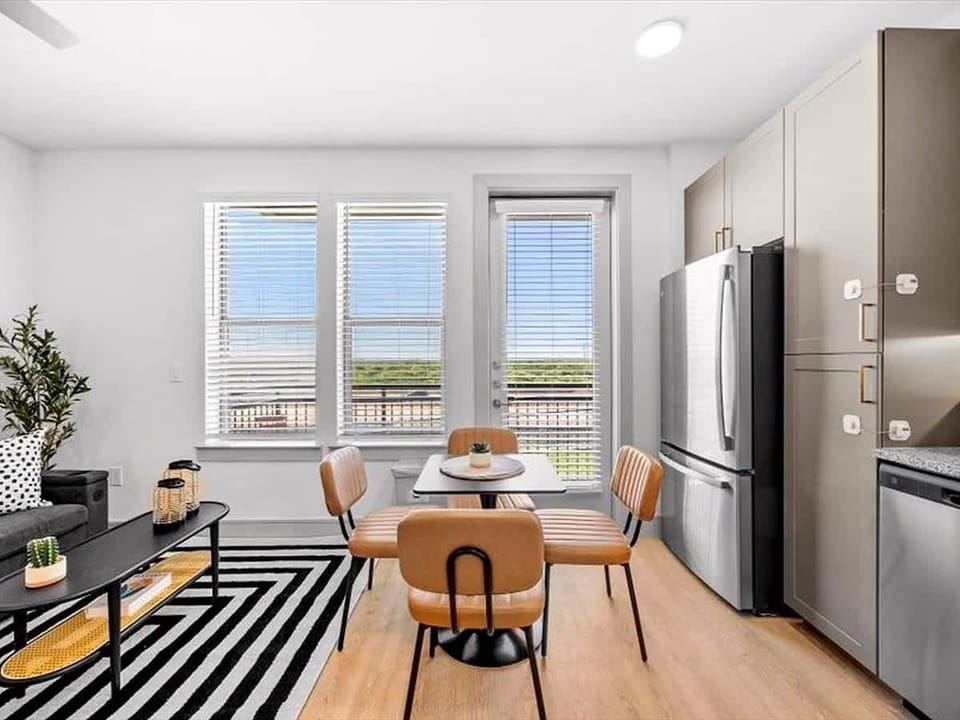 Bright dining nook with seating for four, set beside large windows for plenty of natural light. Perfect for shared meals, work sessions, or morning coffee overlooking the neighborhood.