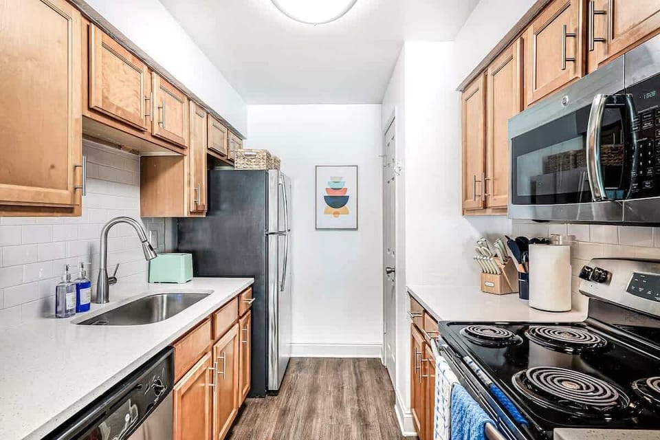 Modern galley kitchen with full-size appliances, wood cabinetry, and quartz countertops for effortless meal prep.