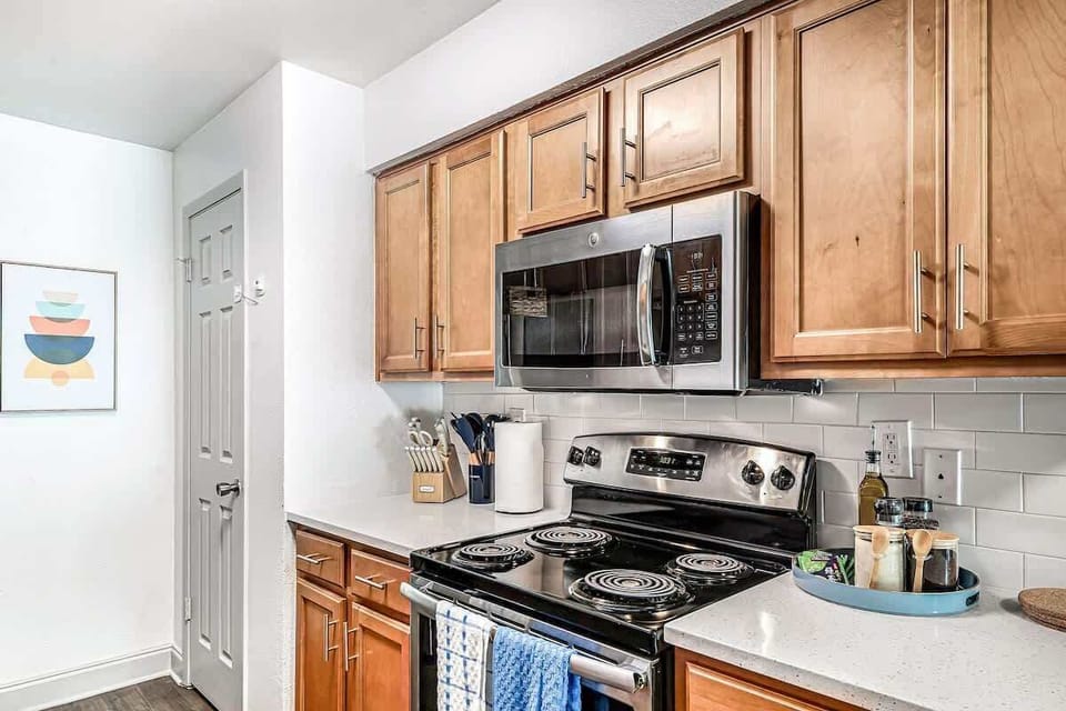 Sleek stainless-steel appliances, stocked essentials, and a bright backsplash ready for your home-cooked meals.