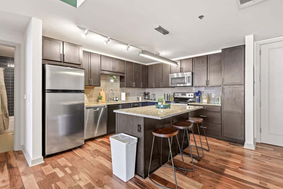 Fully equipped kitchen with stainless steel appliances, granite countertops, and sleek cabinetry  perfect for cooking meals or enjoying morning coffee.