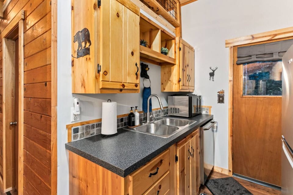 The kitchen has a sink, microwave, dishwasher, fridge/freezer, oven/stove, cutting boards, pots/pans, and more!  The back door leads to the patio, hot tub, grill and firepit.