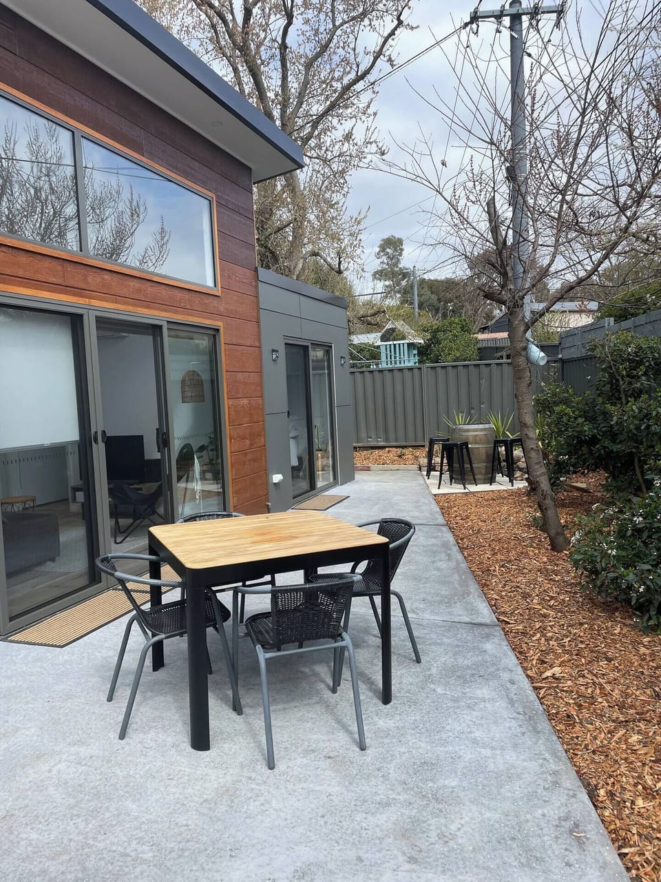 2 outdoor dining areas - table and the wine barrel with high bench seats.

New garden with some established plants - a tall fence with lighting for the evenings :)

Firepit also available and adds the the ambience.