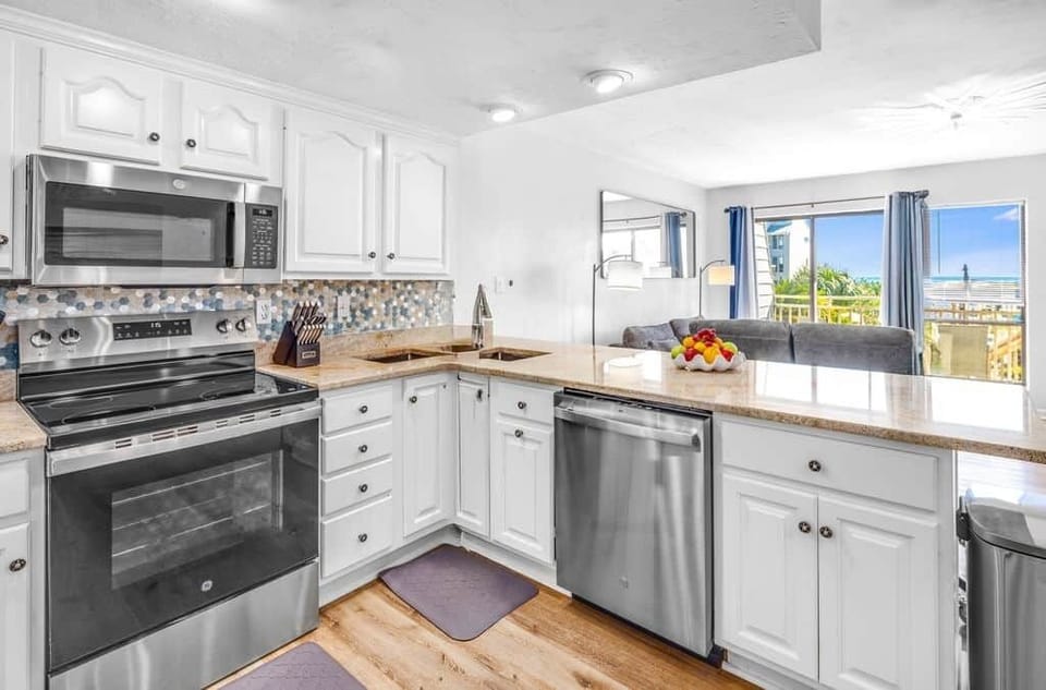 Living room to kitchen—pool sparkle and ocean views steal the show. Breathe it all in.